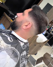 Sharp taper fade with styled top and beard line-up